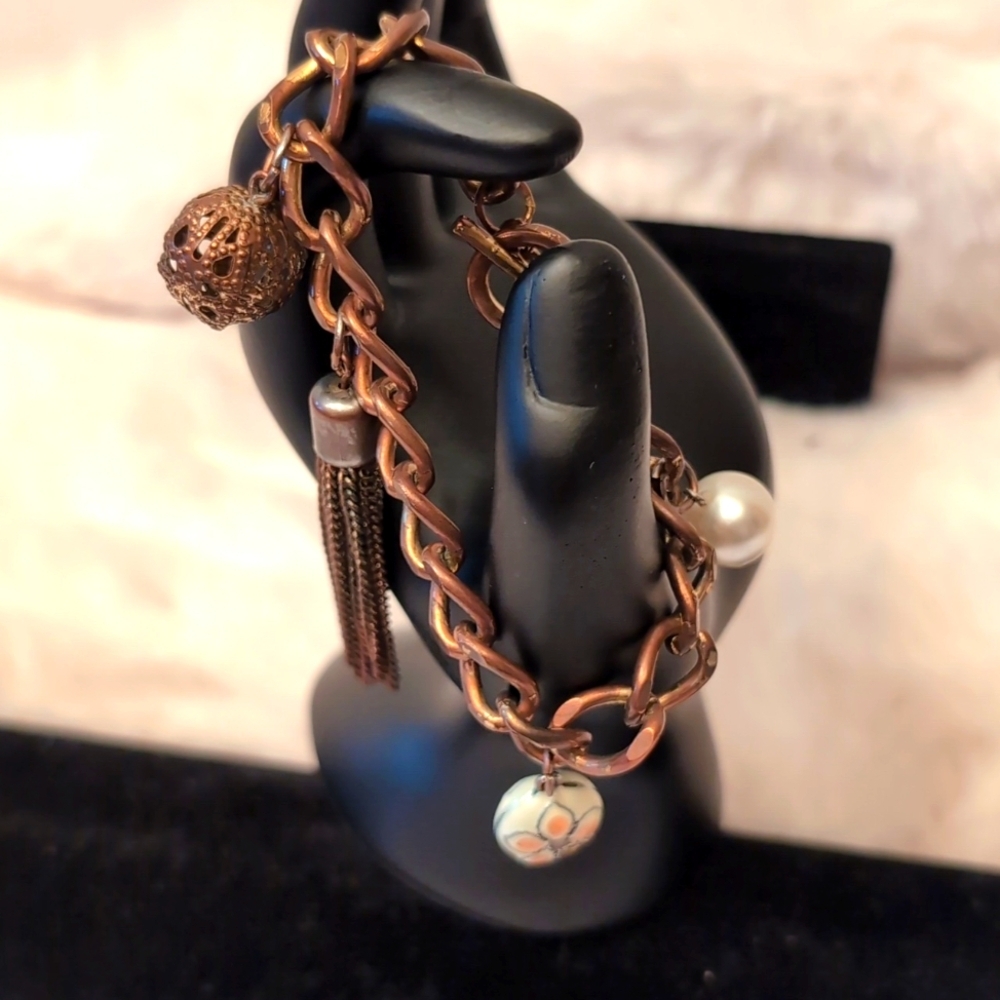 Copper Charm Bracelet With Varied Charms one is a Painted Ceramic Bead Charm